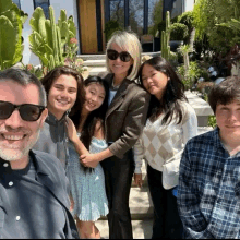 a group of people posing for a picture with a woman wearing sunglasses