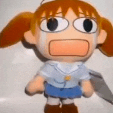 a stuffed doll of a girl with red hair and glasses is crying and making a funny face .