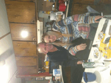 a man and a woman are posing for a picture in the kitchen