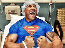 a man in a hospital bed wearing a blue superman shirt