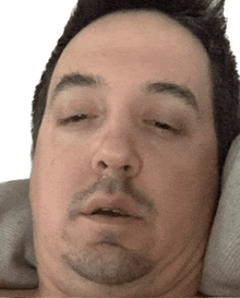 a man with his eyes closed is laying on a couch