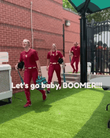 a group of female softball players are walking in a line with the words let 's go baby boomer written on the bottom