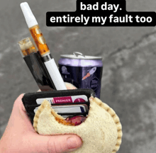 a person holding a wallet with a can of soda and a sandwich with a bite taken out of it