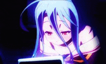 a girl with long blue hair is looking at a cell phone in the dark .