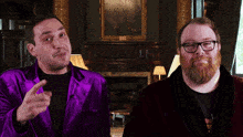 a man in a purple robe is talking to another man in glasses