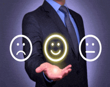 a man in a suit and tie holds up three smiley faces one of which is smiling