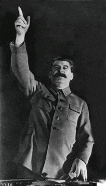 a man with a mustache is pointing up with his hand