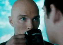 a bald man is drinking from a black mug that says lumion