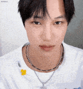 a close up of a person wearing a necklace that says intokai on the bottom
