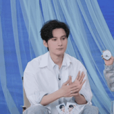 a man in a white shirt is clapping his hands