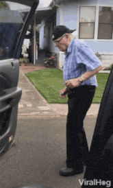 an elderly man is standing next to a car with the trunk open ..