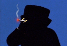 a man in a top hat is smoking a cigarette in the dark