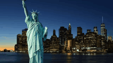 the statue of liberty is in front of a city skyline