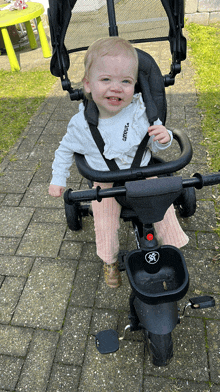 a little girl is sitting in a stroller that says ' stroller ' on it