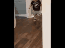 a young boy is running down a hallway .