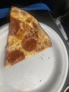 a slice of pepperoni pizza sits on a paper plate