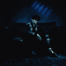 a man sitting on a couch in a dark room