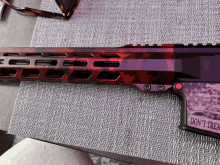 a red and purple gun with a sticker that says " do n't touch "