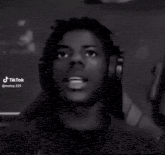 a black and white photo of a young man wearing headphones and looking up .