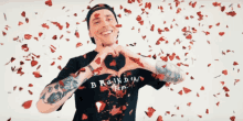 a man making a heart shape with his hands wearing a shirt that says branda