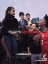 a group of people are standing in front of a sign that says what 's my name on it