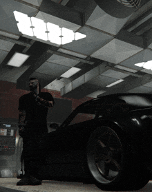 a man with a tattoo on his arm stands next to a black sports car