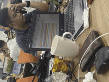 a man sits at a desk with a laptop and a can of red bull