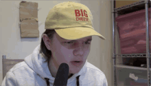 a man wearing a yellow hat that says big cheese on it