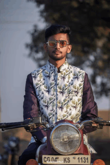 a man is sitting on a motorcycle with a license plate that says cg 04 ks 1131