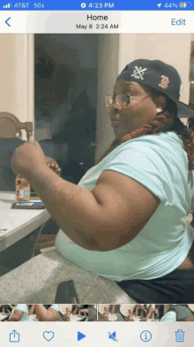 a phone screen shows a photo of a woman wearing a boston red sox hat