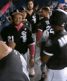 a group of baseball players are standing in a dugout and one of them has the number 21 on his jersey