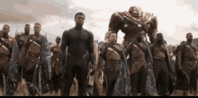 a group of men are standing in a field and one of them is wearing a black panther suit