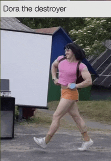 a man is dressed as dora the destroyer and is running down the street .