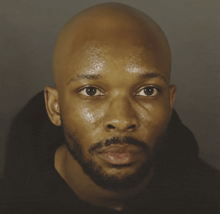 a close up of a man 's face with a bald head and a beard