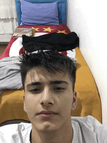 a young man laying on a bed with a blanket that has a flag on it