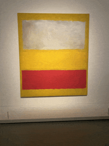 a yellow and red painting is on a white wall