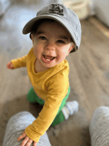 a baby wearing a la hat is smiling