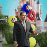 a man in a suit and tie is holding a mickey mouse balloon in front of a castle
