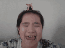 a young girl making a funny face with a clip on her head