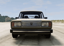a car with a dodge logo on the front is driving on a dirt road