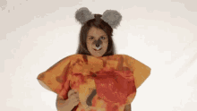 a woman is wearing a koala costume and holding a pizza .