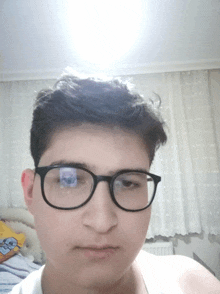 a boy wearing glasses looks at the camera