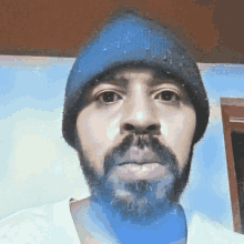 a man with a beard is wearing a blue hat