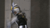 a man in a superhero costume is standing in front of a wall with his arms outstretched