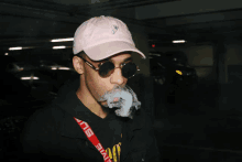 a man wearing a pink hat smoking a cigarette