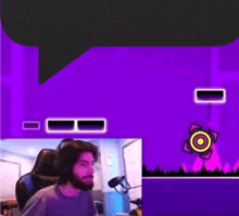 a man with a beard is playing a video game on a computer while wearing headphones .