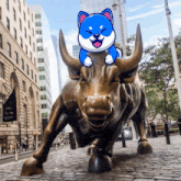 a statue of a bull with a cartoon dog on top of it