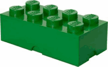 a green lego brick is sitting on top of a white table .