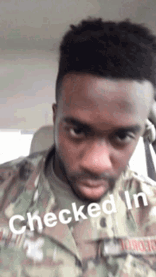 a man in a military uniform is sitting in a car with the words checked in written on his face