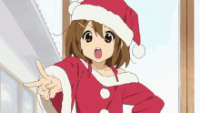 a girl in a santa hat is pointing